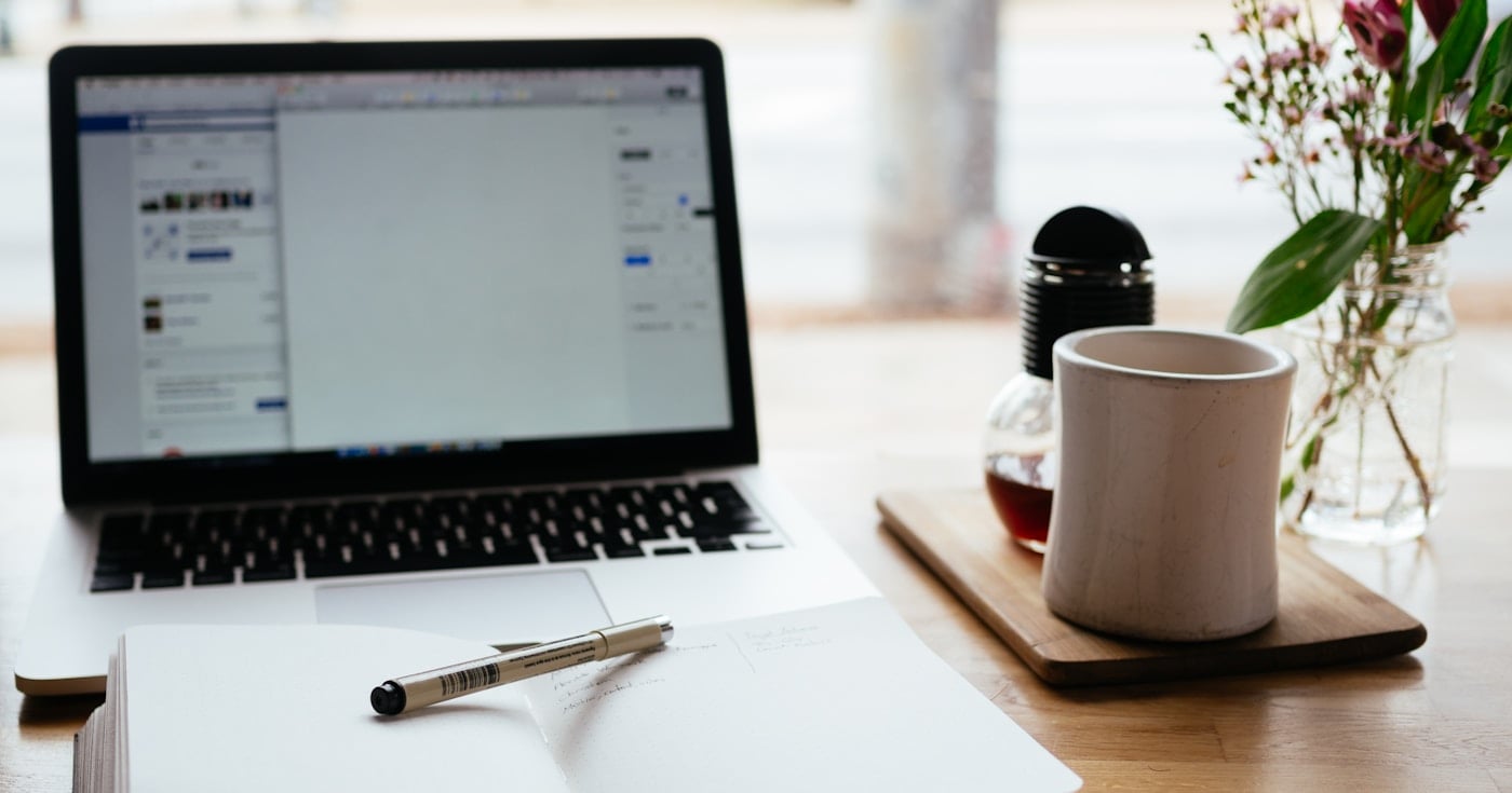 Laptop and notepad on a writing desk