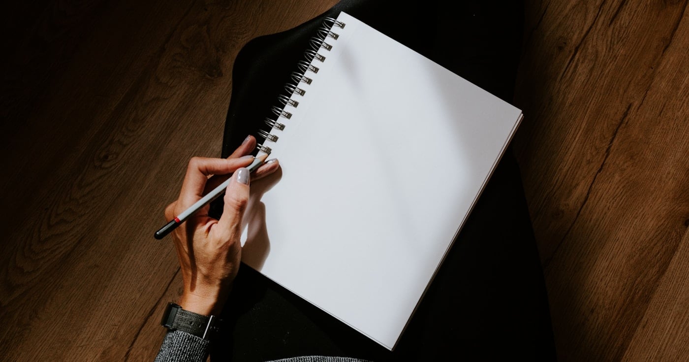 Person writing in notebook practicing freewriting