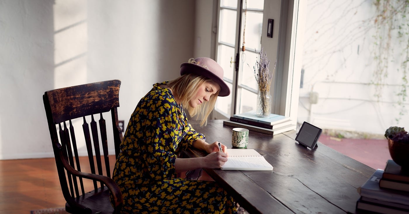 Author sitting at a writing desk working on a manuscript