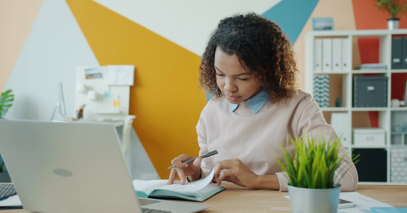 Person focused on writing at a desk