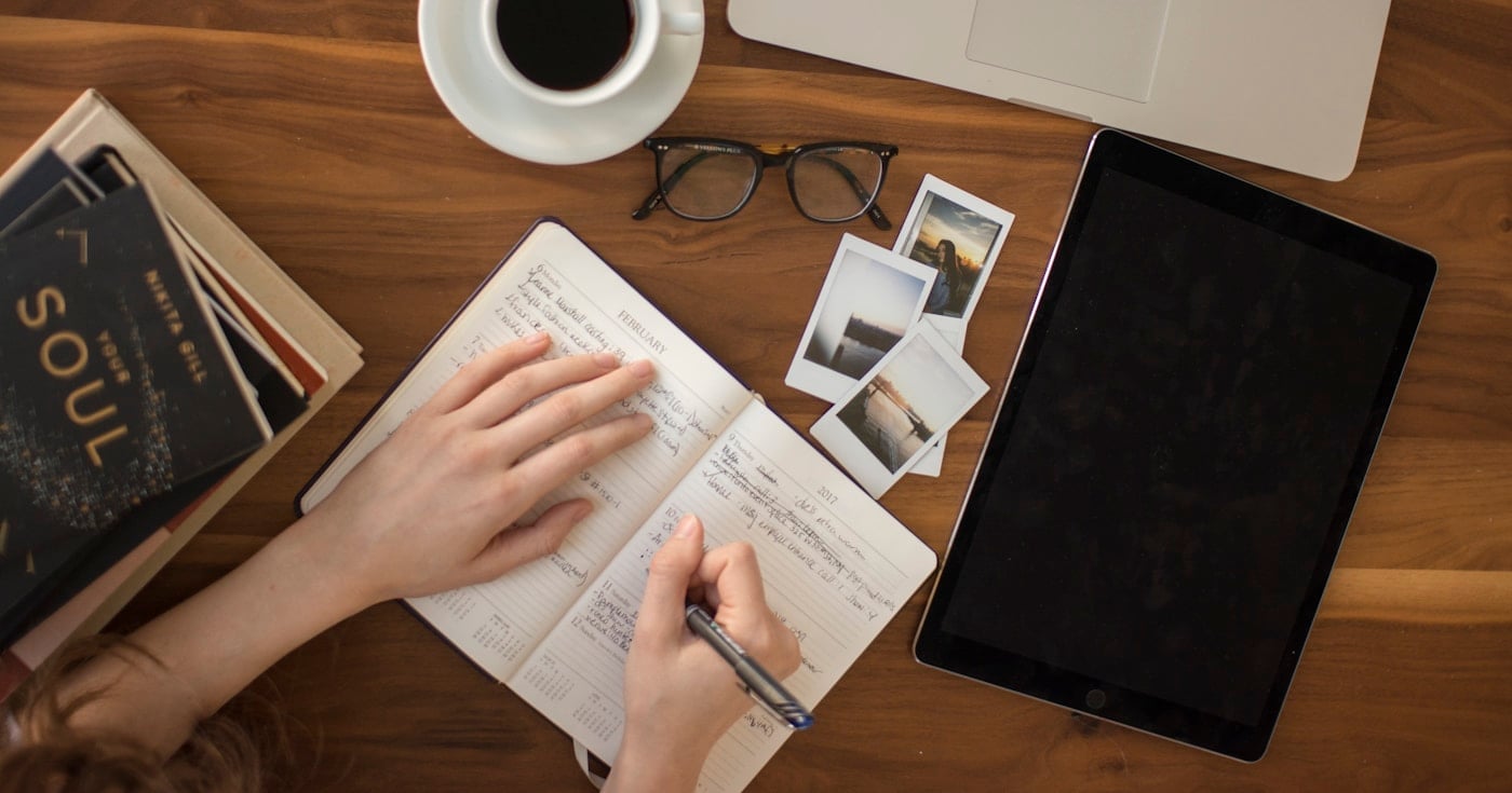 Author's writing desk with notebook and books for hybrid publishing guide