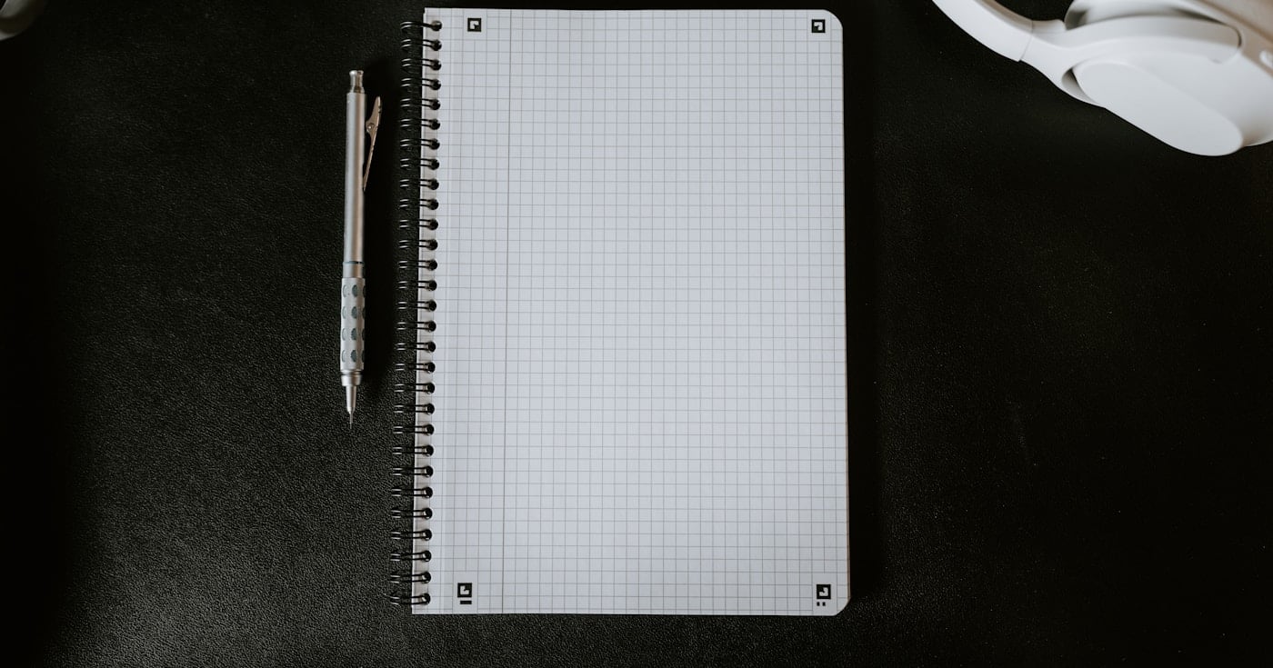 Notebook and pen on desk representing writing craft and grammar