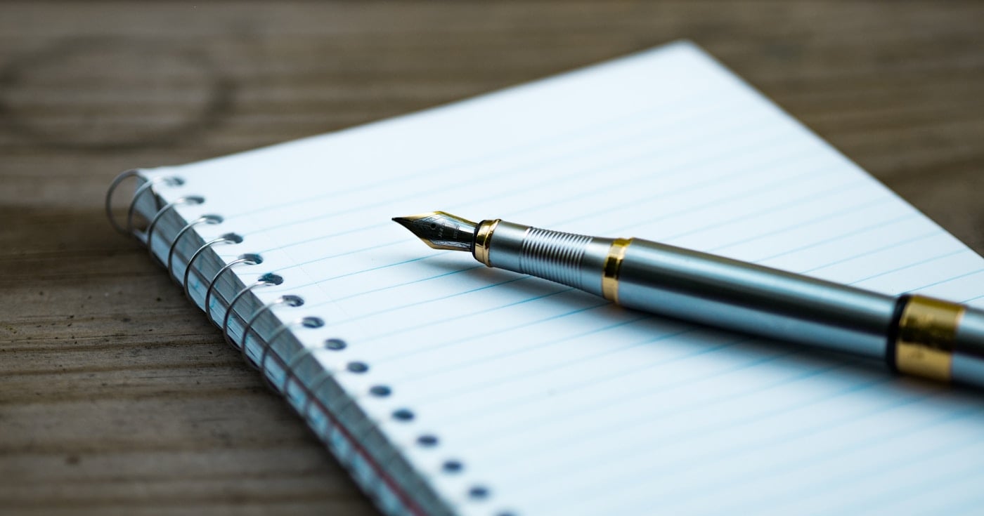 Fountain pen and notebook, representing writing craft and grammar