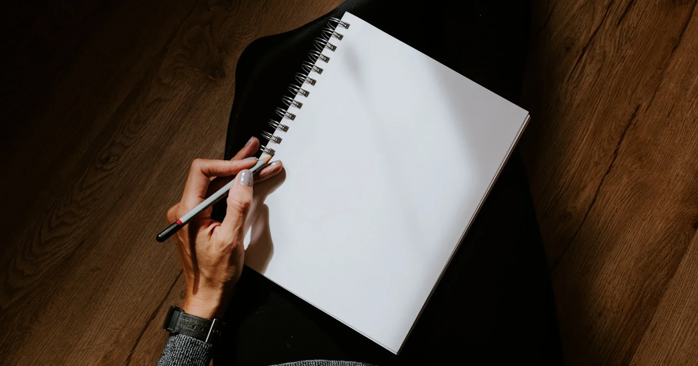 Person writing in notebook practicing freewriting