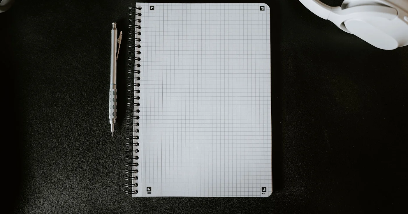 Notebook and pen on desk representing writing craft and grammar