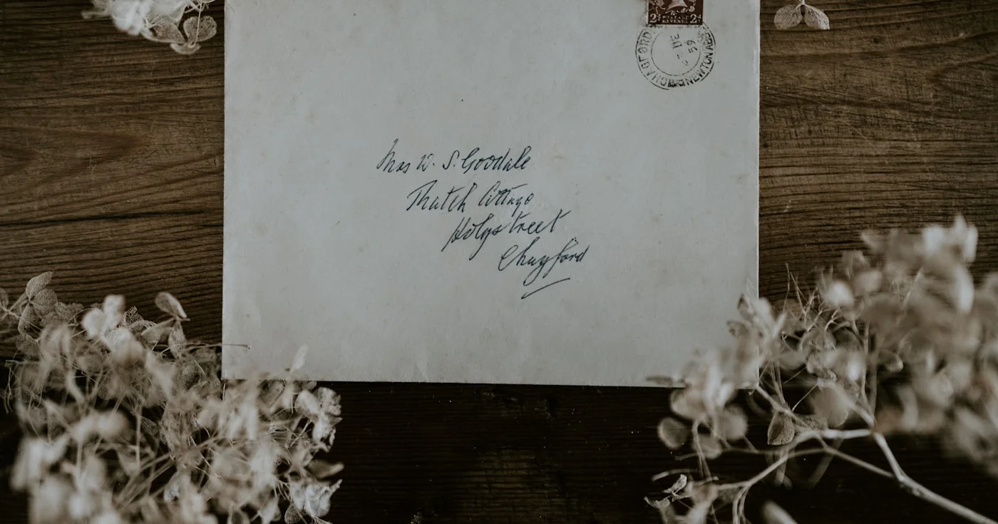 Vintage handwritten envelope with stamp on a wooden table